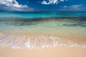 A beach with clear turquoise water and a sandy shore.