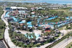 A resort with multiple swimming pools, water slides, and palm trees.