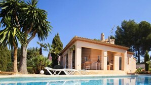A poolside villa with a clear blue pool, palm trees, and a tiled roof. - Flamenco by Interhome (Calpe/Calp)