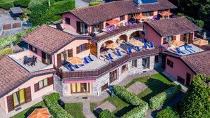 Una casa grande de varios pisos con balcón y zona de estar al aire libre.