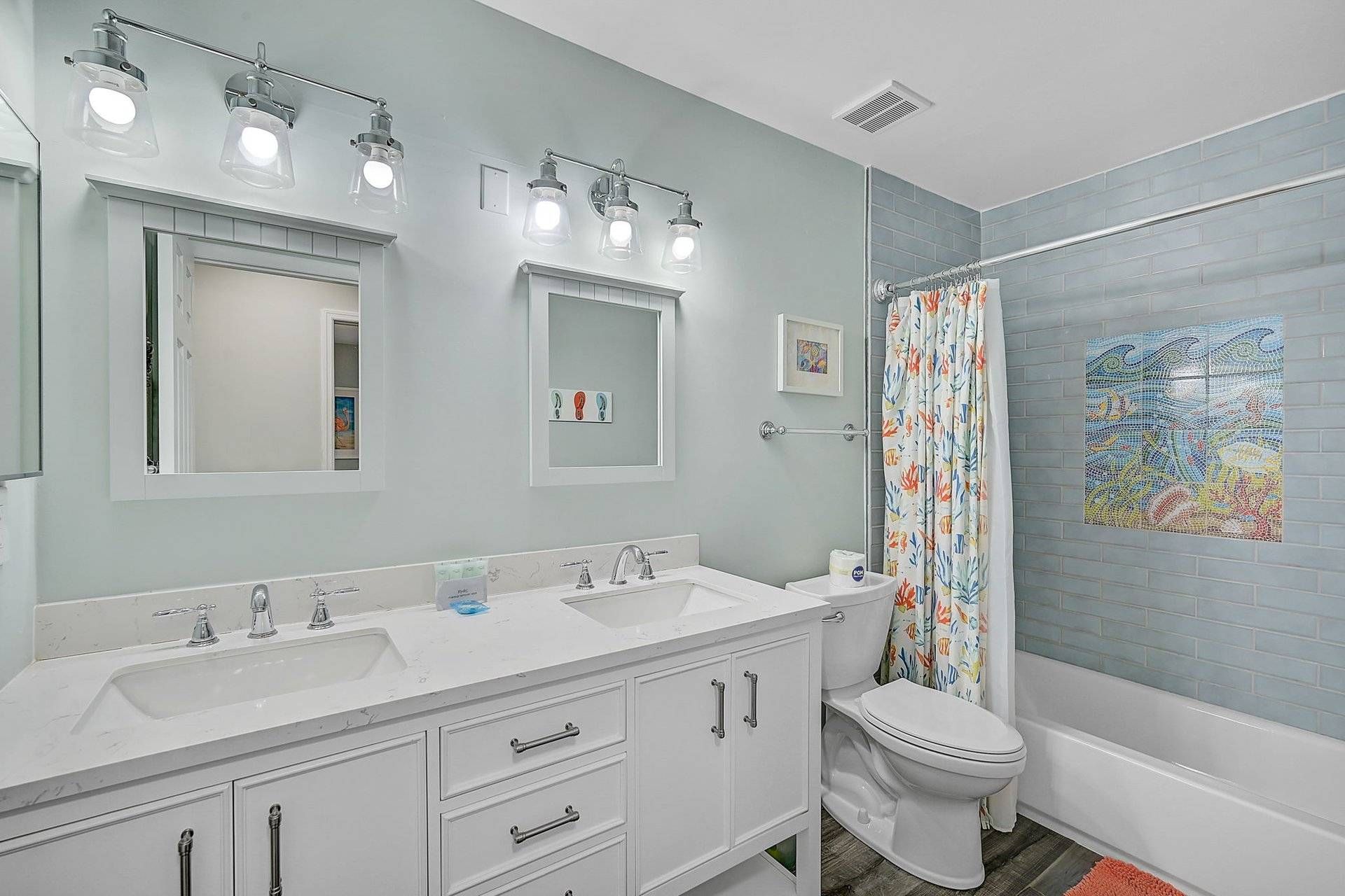 A bathroom with two sinks, a toilet, and a shower.