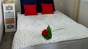 Una camera da letto con un letto, un comodino, una lampada, un quadro e una finestra.
