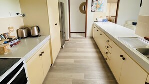A modern kitchen with a central island, a refrigerator, and a stove.