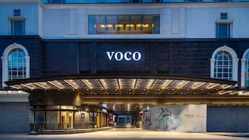 A modern building with a prominent "VOCO" sign above the entrance.