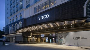 A hotel entrance with a prominent 'VOCO' sign, a modern architectural design, and a large digital display. - voco Guangzhou Shifu by IHG (Guangzhou)