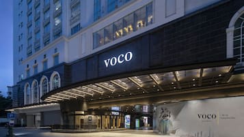 Welcome to VOCO, where guests can enter a contemporary hotel with a sleek main entrance.