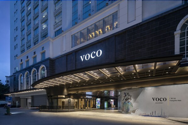 A hotel entrance with a prominent 'VOCO' sign, a modern architectural design, and a large digital display. - voco Guangzhou Shifu by IHG (Guangzhou)