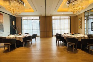 Comedor con mesas redondas, sillas y candelabros.