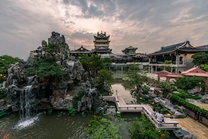 A traditional Chinese garden with a waterfall, koi pond, and classical architecture.