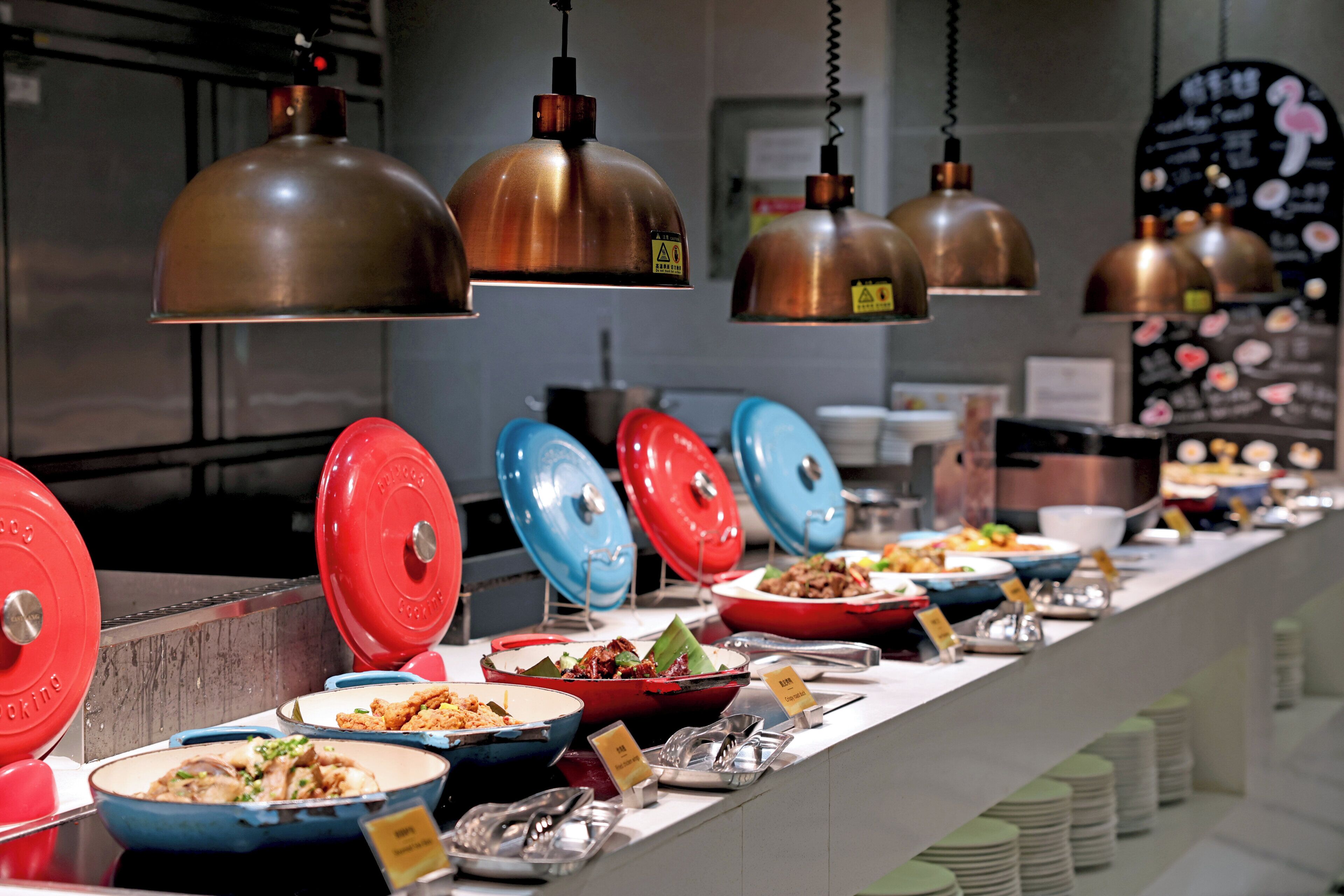 A buffet setup with various dishes and colorful serving ware.