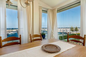 A dining area with a view of a marina and boats.