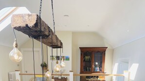 A spacious loft-style apartment with a dining area, kitchen, and living space. - The Granary, 18th Century Luxuriously Restored Barn in the Heart of Tipperary (Thurles)