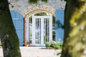 A stone archway leading to a white door with glass panels and a sign reading "The Granary."