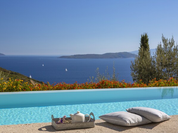A pool with a clear view of the sea and distant islands.