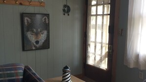 A cozy living room with a plaid sofa, a small wooden table with a decorative object, and a framed picture on the wall. - house with beach and dock access (Willsboro)