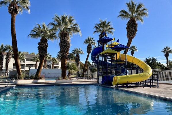 Relax by the pool surrounded by palm trees and enjoy a fun water slide.