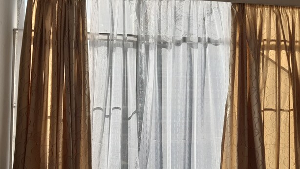 A window with a view of a building's exterior. - Tasumuka Savaal (Johannesburg)