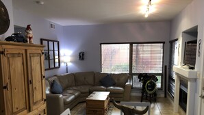 A living room with a leather sofa, wooden cabinet, and a bull's head sculpture. - LAKESHORE VILLAS BEACH COWBOY VILLA (Osoyoos)