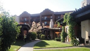 A courtyard with a central pathway, surrounded by buildings with balconies and a covered area. - LAKESHORE VILLAS BEACH COWBOY VILLA (Osoyoos)