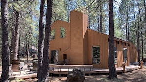 A modern wooden cabin with a deck, surrounded by tall pine trees. - SM BBR home - Perfect for two families! (Sisters)