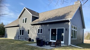 Une maison à deux étages dotée d’un patio couvert.