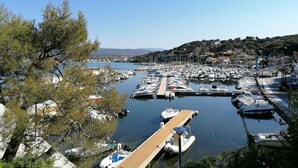 A marina with numerous boats docked, surrounded by trees and a hilly landscape in the background. - A 200 m des Plages Appartement Avec Terrasse & Jardin (Saint-Cyr-sur-Mer)