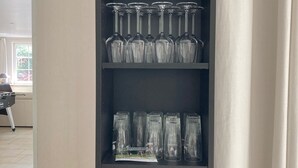 Et vitrineskab med glas, flere hylder.