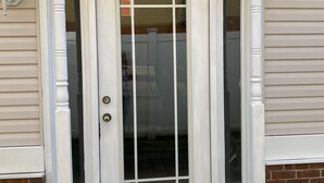 A white front door with a glass panel, flanked by white columns, leading to a brick wall. - NEW! Corner Townhouse: 3BR, 2 balcony home, 2 blocks to beach! (Wildwood)