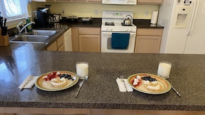A kitchen with two plates of waffles topped with strawberries and blueberries, a glass of milk, and a toaster. - NEW! Corner Townhouse: 3BR, 2 balcony home, 2 blocks to beach! (Wildwood)
