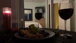 A dining table with a plate of food, two wine glasses, and a candle. - NEW! Corner Townhouse: 3BR, 2 balcony home, 2 blocks to beach! (Wildwood)
