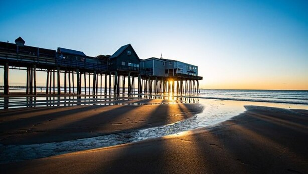 A pier extending into the water with a building at the end.