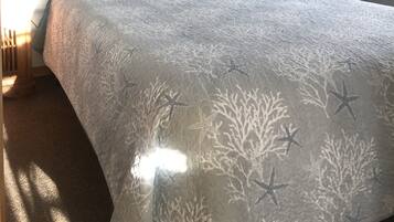 Un dormitorio con una cama, una mesita de noche, una lámpara y adornos en la pared.