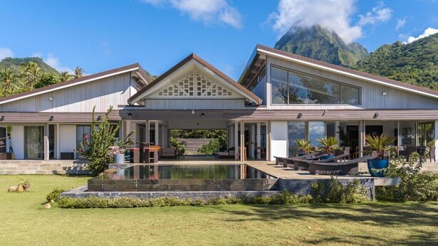 A modern two-story house with a covered patio, a swimming pool, and a mountainous backdrop. - Villa Jessivia Beach (Moorea-Maiao)