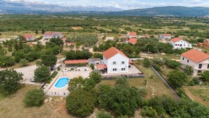 A residential area with houses, a swimming pool, and a mountainous backdrop. - Lovely home in Pridraga (Pridraga)