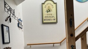 Portaat, joissa on puiset kaiteet, kehystetty kyltti, jossa lukee ”Merenneidon talo”, ja seinälle kiinnitetty kyltti, jossa pyydetään palauttamaan kengät.