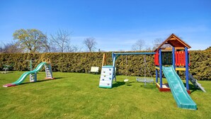 A playground with slides, climbing structures, and a small playhouse. - Beautiful home in Postomino (Postomino)