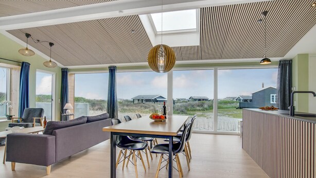 Een modern interieur met een eethoek, bank en keuken.