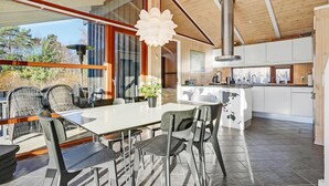 Una cocina moderna con gabinetes blancos, una campana extractora de acero inoxidable y una isla grande con diseño de mapa.