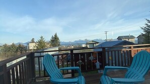 Une terrasse avec deux chaises et une table, offrant une vue sur un paysage montagneux.