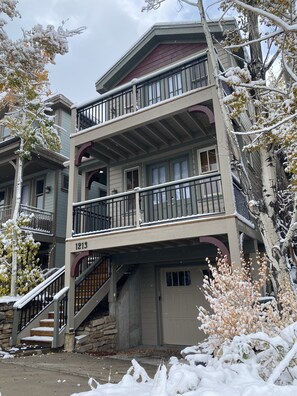 A multi-story building with a balcony on the second floor and a staircase leading to the entrance.