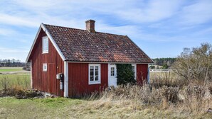 A red wooden house with a tiled roof, a chimney, and a white door. - 2 bedroom beautiful home in Söderåkra (Söderåkra)