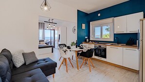 Una cucina moderna con mobili bianchi, un frigorifero nero e una finestra con vista.