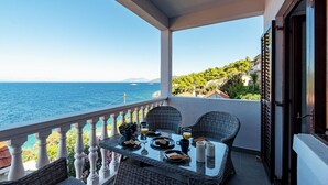 Un balcone con un tavolo apparecchiato per la colazione, con vista sulla costa.