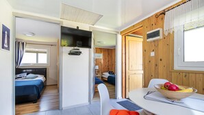 A compact room with a bed, a small table with a bowl of fruit, and a chair. - Beautiful home in Postomino (Postomino)