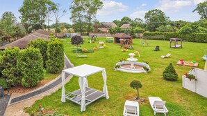 A well-maintained backyard with a lawn, a small fountain, outdoor furniture, and a gazebo. - Beautiful home in Postomino (Postomino)