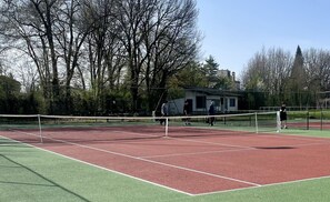 Enjoy a game of tennis on our outdoor court surrounded by lush trees and a scenic view.