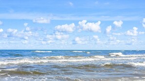 Una playa con olas y un cielo despejado.