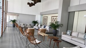 A spacious lobby with a long dining area, several sofas, and potted plants. - OCEAN VIEW APARTMENT on the beach (Nueva Gorgona)