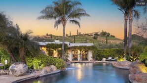 A private pool area with a house in the background, surrounded by palm trees and greenery. - Spectacular Mountain & Vineyard View Estate in the Malibu Wine Trail (Malibu)