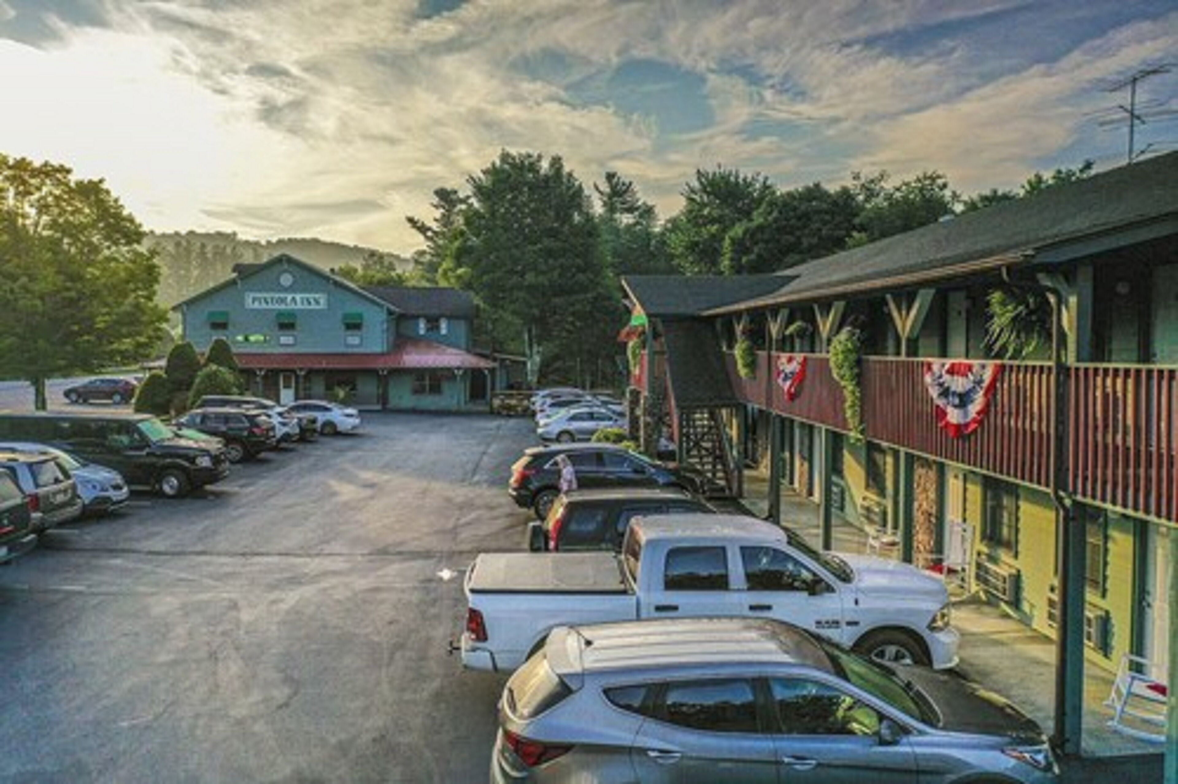 A parking lot with several cars parked in front of a building labeled "Pinnacle Inn."
